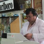 Immagine di un tabaccaio che mostra biglietti del Gratta e Vinci con un sorriso soddisfatto.