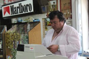 Immagine di un tabaccaio che mostra biglietti del Gratta e Vinci con un sorriso soddisfatto.