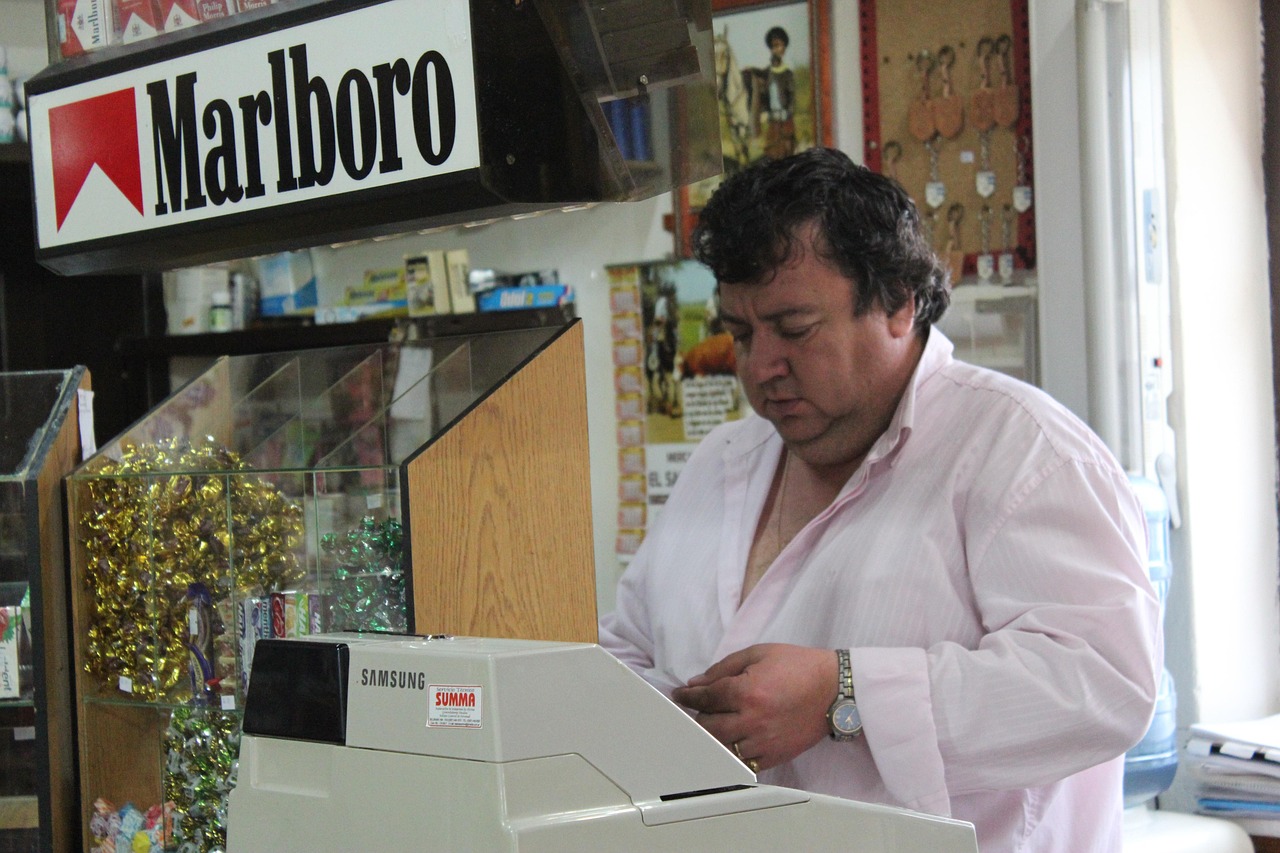 Immagine di un tabaccaio che mostra biglietti del Gratta e Vinci con un sorriso soddisfatto.