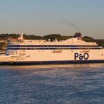 Anziano in barca mentre consulta le nuove tariffe scontate per trasporti marittimi.